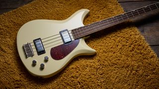 Gretsch Electromatic CVT Bass Double-cut: the retro-styled cream-colored four-string is pictured in close-up against a shaggy brown carpet.