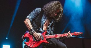 Joe Perry plays his red custom Dazzle guitar onstage with Aerosmith.